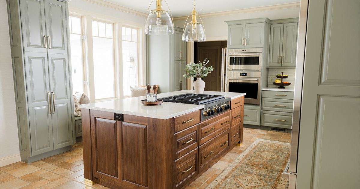 Kitchen with freshly painted green cabinets and stunning wooden island.